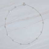 Delicate gold-tone necklace featuring twelve evenly spaced bezel-set sparkling stones along a fine chain, offering a dainty and radiant look
