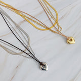 Collar de cadena y corazón perfectamente superpuesto