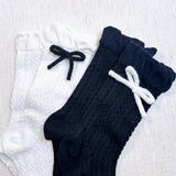 Set of two cozy socks featuring soft yarn bow accents, combining comfort with a touch of playful charm.