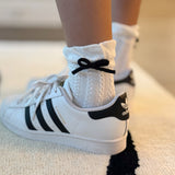 Set of two cozy socks featuring soft yarn bow accents, combining comfort with a touch of playful charm.