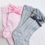 Set of two cozy socks featuring soft yarn bow accents, combining comfort with a touch of playful charm.