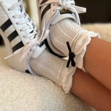 Set of two cozy socks featuring soft yarn bow accents, combining comfort with a touch of playful charm.