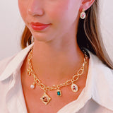 Chunky gold-link necklace featuring a mix of whimsical charms including an angel, rose, and gem accents—blending vintage elegance with romantic flair.