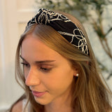 A solid-color knotted headband accented with subtle white stitching for a simple yet refined look.