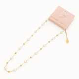 Gold and pearl necklace on a white background with a pink card displaying 'Eliot & Young'.