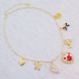 Gold-tone charm necklace featuring a dreamy mix of rose, ballet shoe, angel, and swan charms—blending grace, romance, and whimsy into a delicate statement piece.