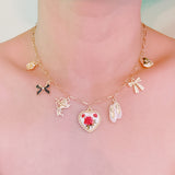 Gold-tone charm necklace featuring a dreamy mix of rose, ballet shoe, angel, and swan charms—blending grace, romance, and whimsy into a delicate statement piece.