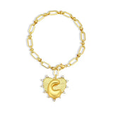 Gold bracelet with a heart-shaped pendant on a white background