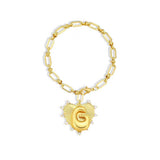 Gold bracelet with a heart-shaped charm featuring the letter 'G' on a white background