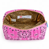 A pink quilted cosmetic pouch with a black and white paisley bandana pattern on the exterior and a leopard print lining, shown open on a white background.