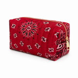 A red quilted cosmetic pouch with a black and white paisley bandana pattern and a gold zipper.