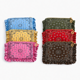 Six bandana-pattern zip pouches with ruffled edges are arranged in two columns of three on a light gray background. The left column shows blue, yellow, and pink pouches, and the right column shows olive green, red, and brown pouches.