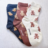 Cute and cozy set of three socks featuring playful bear designs in soft, neutral tones—perfect for adding a touch of whimsy to your everyday look.