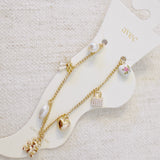 Delicate gold anklet adorned with playful charms including a bear, ribbon, heart, and pearl accents—adding a sweet and whimsical touch to your summer look.