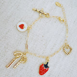 Gold charm bracelet with strawberry, heart, and bow – romantic playful bracelet