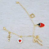 Gold charm bracelet with strawberry, heart, and bow – romantic playful bracelet