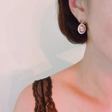 Antique-inspired black and gold drop earrings featuring an ornate cameo profile framed in gold with delicate bow-shaped top accents