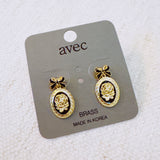 Antique-inspired black and gold drop earrings featuring an ornate cameo profile framed in gold with delicate bow-shaped top accents
