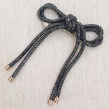 Hair clip featuring a sparkly tube-style bow embellished with rhinestones, perfect for adding a touch of glam to any hairstyle.