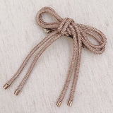 Hair clip featuring a sparkly tube-style bow embellished with rhinestones, perfect for adding a touch of glam to any hairstyle.