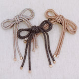 Hair clip featuring a sparkly tube-style bow embellished with rhinestones, perfect for adding a touch of glam to any hairstyle.