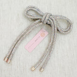Hair clip featuring a sparkly tube-style bow embellished with rhinestones, perfect for adding a touch of glam to any hairstyle.