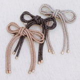 Hair clip featuring a sparkly tube-style bow embellished with rhinestones, perfect for adding a touch of glam to any hairstyle.
