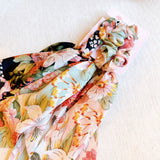 Trio of scarf hair scrunchies with colorful blooming floral patterns and soft, flowing ribbons—ideal for adding a lively, festival-ready touch to any look.