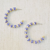 Stylish hoop earrings featuring delicate blue floral accents, offering a fresh and elegant look inspired by nature—ideal for springtime or everyday wear.