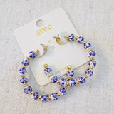 Stylish hoop earrings featuring delicate blue floral accents, offering a fresh and elegant look inspired by nature—ideal for springtime or everyday wear.