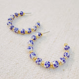 Stylish hoop earrings featuring delicate blue floral accents, offering a fresh and elegant look inspired by nature—ideal for springtime or everyday wear.