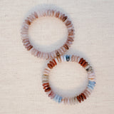 Stretch bracelet made of natural stone disc beads in soft blush, beige, and taupe tones arranged in a gradient pattern