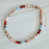 Beaded necklace made with natural stone disc beads in warm blush, beige, and soft brown tones arranged in a smooth, gradient pattern.