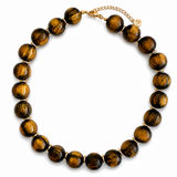 A beaded necklace made of polished tiger's eye beads with gold spacer rings and a gold chain clasp, displayed on a clean white background.
