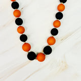 Necklace with black and orange beads on a white background