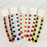 Colorful beaded necklaces on display with tags, set against a light background.