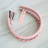 A set of padded fabric headbands in assorted pastel and plaid designs, including soft pink, green tones. Each headband features a cushioned, textured surface that blends solid and patterned fabrics for a stylish, comfortable everyday accessory.