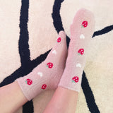 Set of two fuzzy socks featuring cute cherry and strawberry designs, adding a sweet and cozy touch to your loungewear.