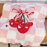 Pink and white checkered blanket with red cherries and a bow design.