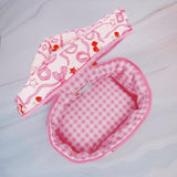 Travel-friendly cosmetic case with top handle, featuring a charming cherry and bow print, ideal for organizing beauty essentials on the go.