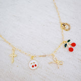 Gold necklace with cherry, cross, and bow charm – playful Y2K accessory