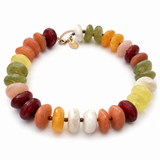 A beaded stretch bracelet made of polished oval gemstone beads in multiple colors including orange, green, yellow, white, pink, and deep red, with a small gold clasp and charm, shown on a white background.