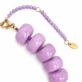 Purple beaded bracelet with gold clasp on a white background