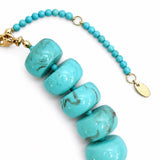Turquoise beaded bracelet with gold clasp on a white background