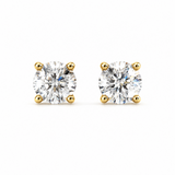 A pair of round-cut diamond stud earrings in yellow gold four-prong settings, shown on a plain white background.
