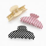 Three striped hair clips in yellow, red, and black on a white background
