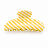 Yellow and white striped hair clip on a white background