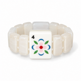 A beaded bracelet featuring translucent off-white rectangular beads and a central square tile with a floral design in pink, blue, green, and red, resembling a mahjong tile.
