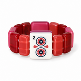 A beaded bracelet featuring translucent red and pink glass beads surrounding a central white square tile printed with a red and navy blue flower motif and the number 2.