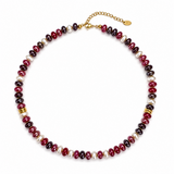 A beaded necklace featuring alternating dark red, black, and white pearl-like beads, accented with small gold spacer beads and a gold clasp with extender chain on a white background.